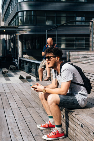 Man with smartphone sitting on steps in High Lineのeditorial素材