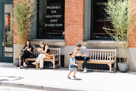 People sitting on benches enjoying lunch in Soho in New Yorkのeditorial素材