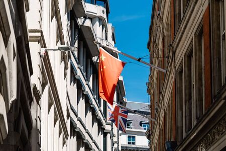 Low angle view of Chinese and UK flag in London
