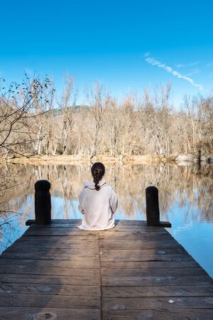 Young woman sitting on pierの写真素材