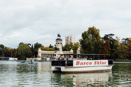 Solar powered boat in the Great Pond of Buen Retiro Park a sunny day of Autumnのeditorial素材