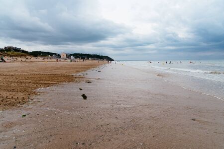 Beach with dark clouds and incoming rain storm. Vacation with bad weather conceptの写真素材