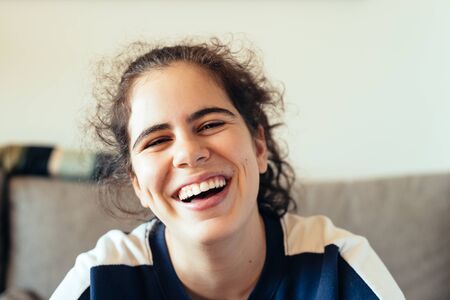 Happy cheerful teenager rejoicing at positive news or birthday gift, looking at camera with joyful...