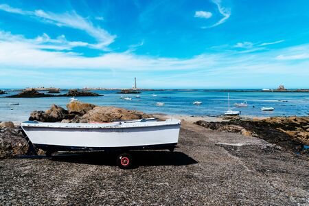 Boat out of water in the pier against bay with lighthouse a sunny day of summerの写真素材
