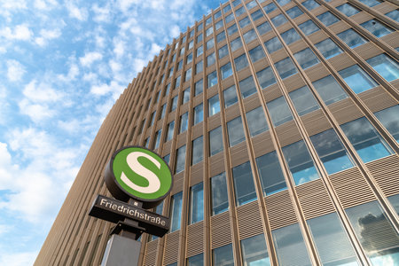 Low angle view of Friedrichstrasse railway station sign against modern office buildingのeditorial素材