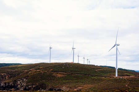 Wind turbines on field against sky in Galiciaの写真素材