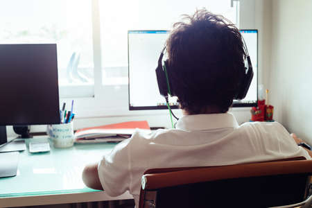 Teenager is studying at home attending online classesの写真素材
