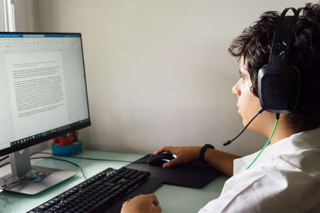Teenager is studying at home attending online classesの写真素材