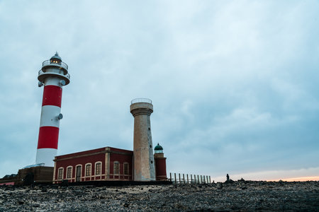 Scenic view of El Toston Lighthouse in Canary Islands amidst volcanic landscapeのeditorial素材