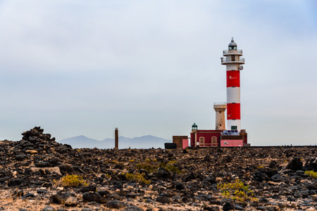 Scenic view of El Toston Lighthouse in Canary Islands amidst volcanic landscapeのeditorial素材