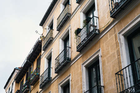 Low angle view of old cast iron balconies of old residential building in Lavapies quarter in Madridの写真素材