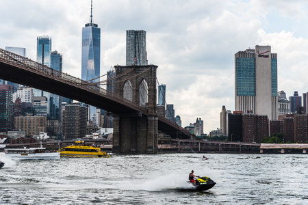 Cityscape of Downtown of Manhattan and Brooklyn Bridge with jet skiのeditorial素材