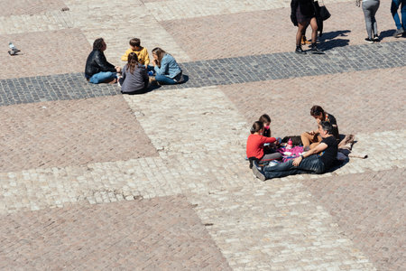 People eating sitting on the floor in Plaza Mayor Square in Madridのeditorial素材