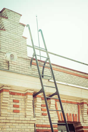 Steel Ladder on Brick Building With Sun Flareの写真素材