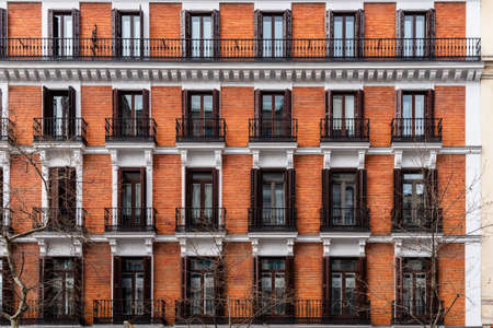 Elevation View of Old Luxury Residential Building with Brick Facade and Balconiesの写真素材