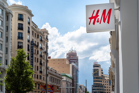 H and M fashion store sign in Gran Via against cityscape in Madridのeditorial素材