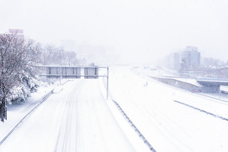 Empty highway covered in snow with trapped cars during heavy snowfall stormのeditorial素材