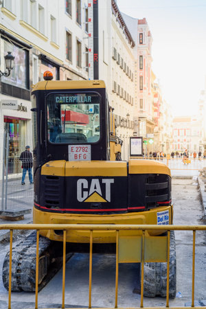 CAT backhoe working on public works on the street in central Madridのeditorial素材