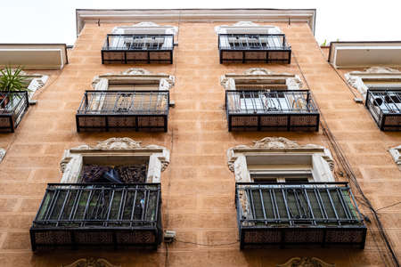 Low angle view of old cast iron balconies of old residential building in Lavapies quarter in Madridの写真素材