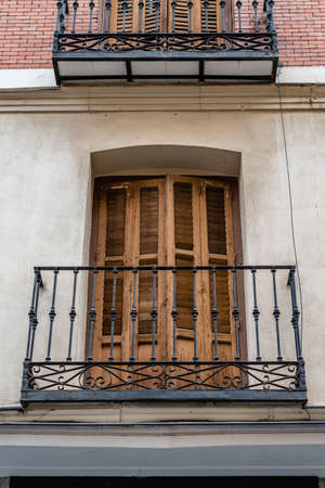Low angle view of old cast iron balconies of old residential building in Lavapies quarter in Madridの写真素材