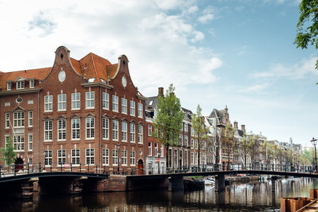 Scenic view of Kloveniersburgwal canal with typical Dutch houses in Amsterdamのeditorial素材