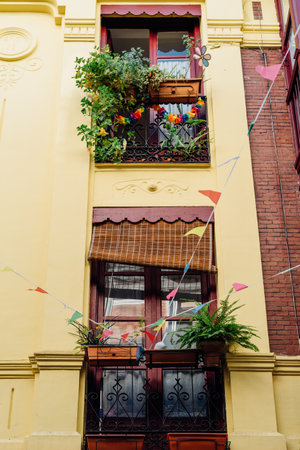 Traditional iron balcony with pots hanging from the railingの写真素材