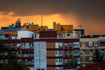 Dramatic view of residential neighborhood at stormy orange sunset in Madridのeditorial素材