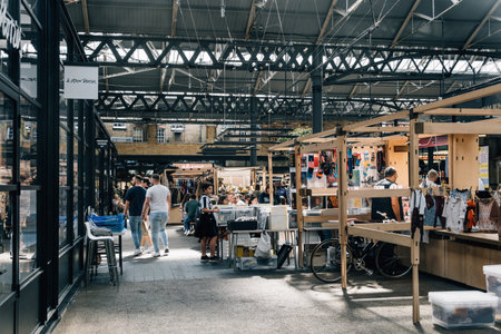 London, UK - August 25, 2023: Old Spitalfields Market is the original East London Market Place. Retailers, Restaurants, Market Stalls and Street Food Traders under one Victorian Market Roof at the Heart of London. interior viewのeditorial素材