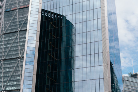 London, UK - August 25, 2023: Reflections on curtain wall glass facade of modern office skyscrapers in the City of London.のeditorial素材