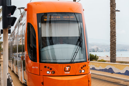 Alicante, Spain - October 14, 2023: Orange streetcar running along the promenade between Alicante and San Juanのeditorial素材