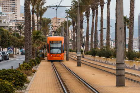Alicante, Spain - October 14, 2023: Orange streetcar running along the promenade between Alicante and San Juanのeditorial素材