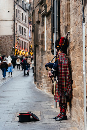 Edinburgh, UK - December 3, 2023: Bagpiper playing traditional Scottish tunes at the Royal Mile...