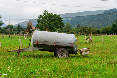 A trailer tank for watering the fields in a valley of the Saja river in Cantabria, Spain. The tank...
