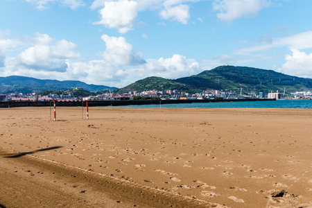 A scenic view of a sandy beach in Getxo with mountains in the background on a clear, sunny day.の写真素材