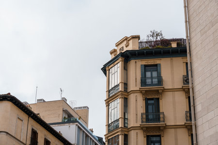 A view of Madrid's architecture showcasing a classic residential building with balconies, set against a cloudy sky.の写真素材