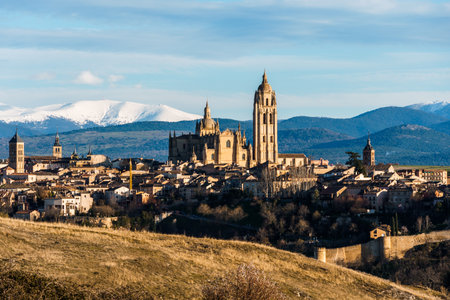 Panoramic view of the historic city of Segovia, Spain, with the Guadarrama mountains in the background on a sunny day.の写真素材