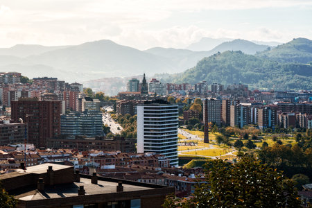 An aerial view showcases Bilbao urban landscape, blending contemporary skyscrapers with classic architecture, bathed in sunlight.の写真素材