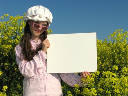 Pretty girl holding blank white sign in yellow field