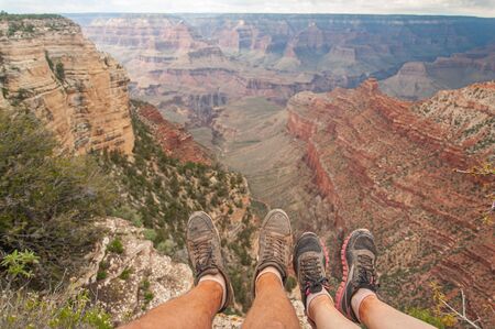 couple sitting on the edge of a cliff