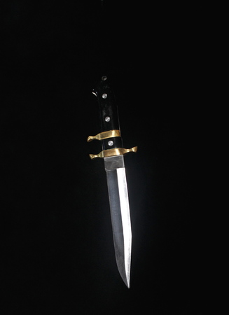 Combat knife, large size, against the background of the night, moon sky, in the pre-dawn mist, with artificial lighting.の写真素材