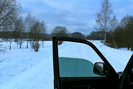 View from the car window on winter landscape with trees and road.の写真素材