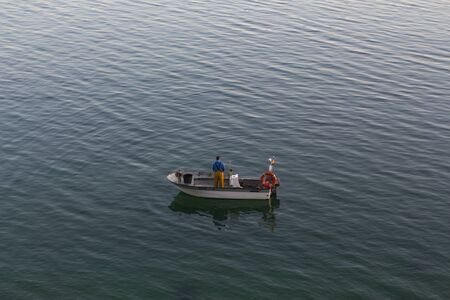 Fisherman fishing on a little boat