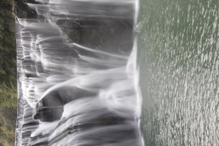 Long exposure of a waterfall flowing down a cliff into the sea.の写真素材