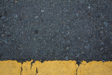 Asphalt road texture with below yellow stripe の写真素材