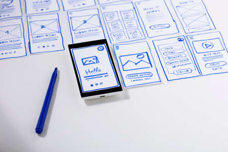 User experience design, desk with paper sketches for mobile interface