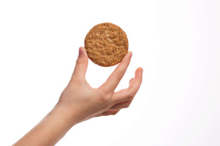 Little boy hand holding a whole grain cookie biscuitの写真素材