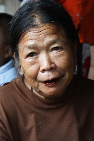 Karen Woman with lips and teeth covered with brown colour in tribal village in Chiang Mai, Thailand - 31.07.2011のeditorial素材