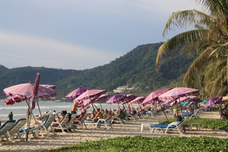 People rest at the tropical beach Patong at Phuket in Thailand - 09.08.2011のeditorial素材