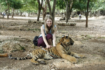 Caucasian young tourist woman and the Tiger in a Tiger Temple, Kanchanaburi province, Thailandの写真素材