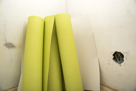 Rolls of green wallpaper ready for application to wallの写真素材